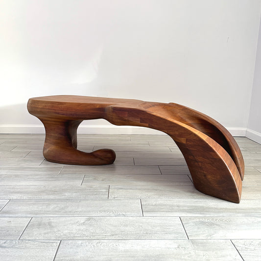 A wood carved, biomorphic sculptured coffee table made of laminated walnut with an organic, abstract form in the style of Wendell Castle