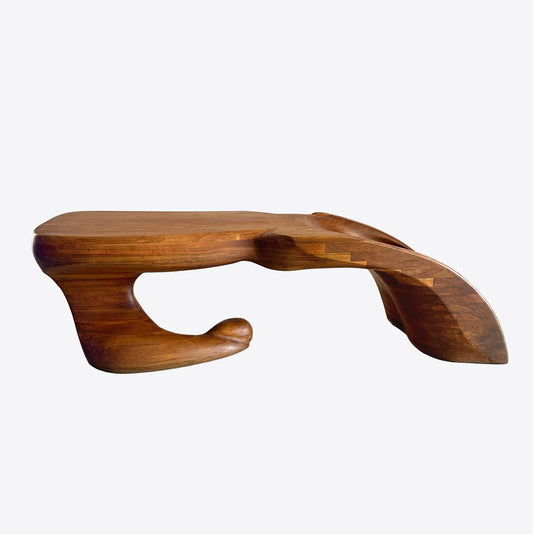 A wood carved, biomorphic sculptured coffee table made of laminated walnut with an organic, abstract form in the style of Wendell Castle